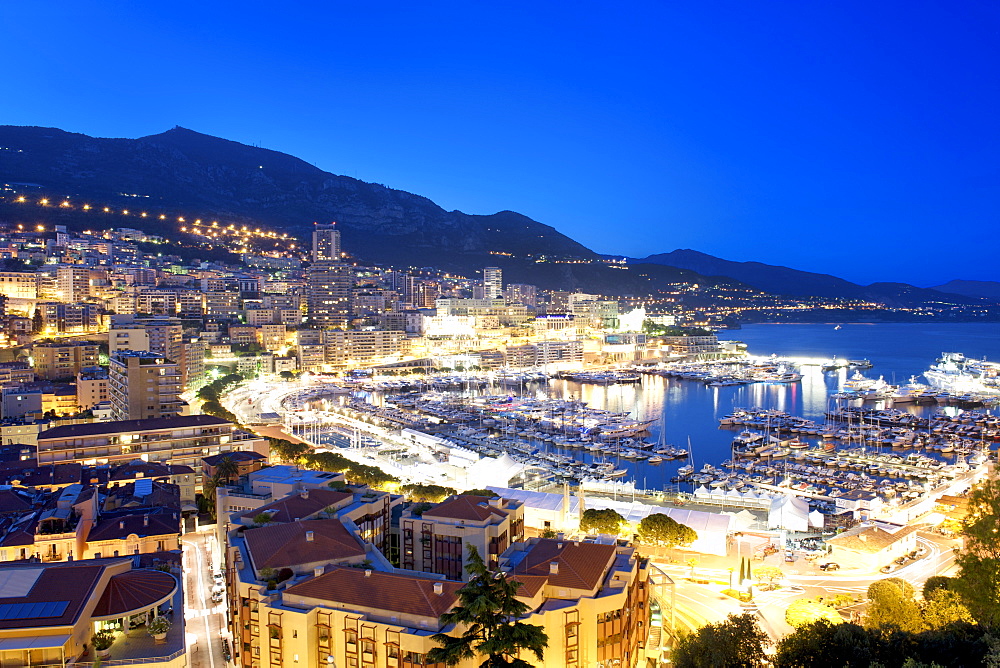 Dusk view across Port Hercule and the city and Principality of Monaco, Cote d'Azur, French Riviera, Mediterranean, Europe