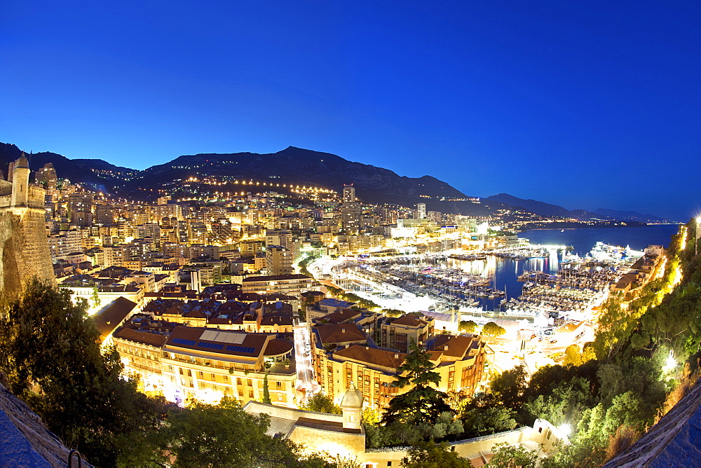 Dusk view across Port Hercule and the city and Principality of Monaco, Cote d'Azur, French Riviera, Mediterranean, Europe