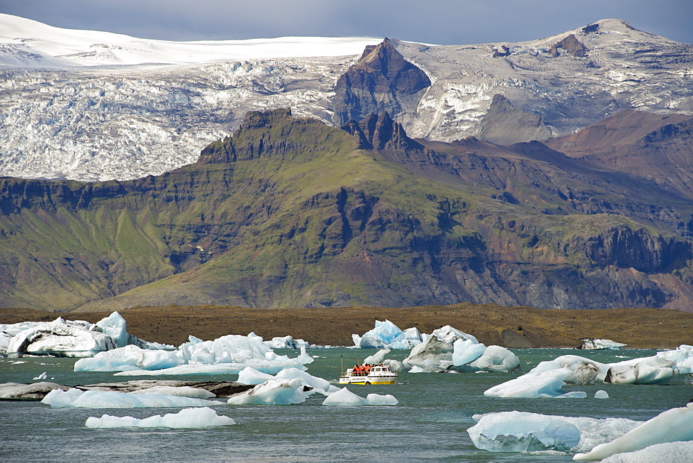 A tourist boat among the icebergs floating in Jokullsarlon lake at the foot of the Vatnajokull glacier, in the southeast, Iceland, Polar Regions