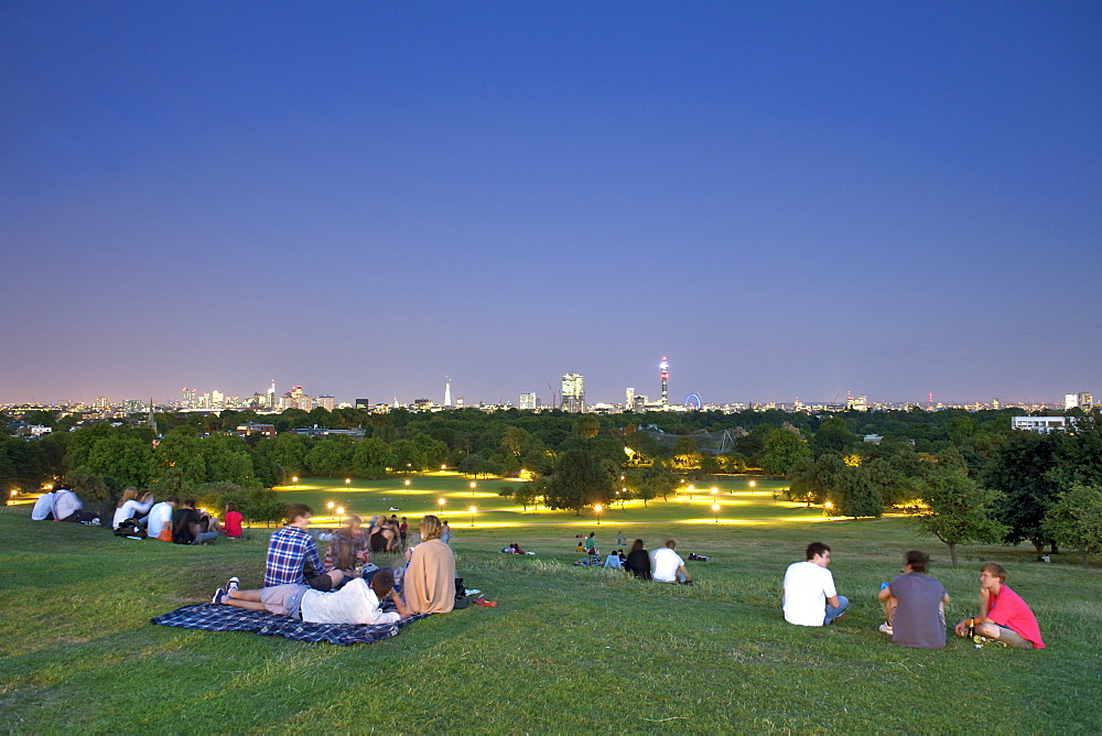 A dusk view of the London skyline from Primrose Hill showing the park, London, England, United Kingdom, Europe