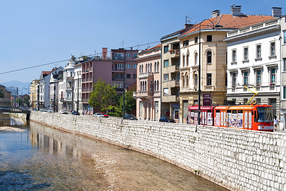 Buildings along Obala Kulina Bana road on the north bank of the Miljacka River in Sarajevo, capital of Bosnia and Herzegovina, Europe