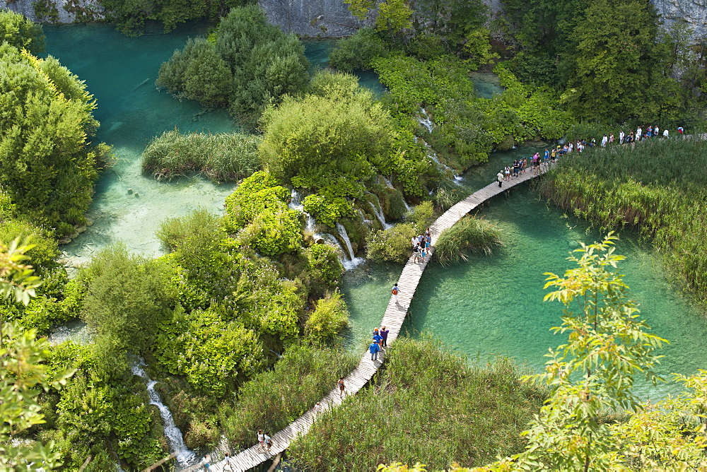 Tourists walking along wooden walkways in Plitvice Lakes National Park, UNESCO World Heritage Site, Croatia, Europe