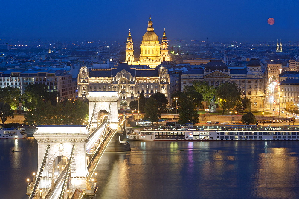 Full moon over city, with Szechenyi Chain Bridge and the dome of St. Stephen's Basilica, Budapest, Hungary, Europe