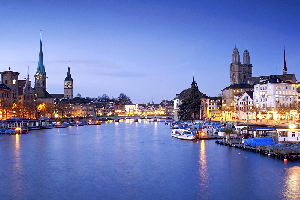 Dusk view of the Limmat River and old town of Zürich Switzerland. On the left are the churches of Fraumünster and St Peter's, on the right the twin towers of the Grossmünster church. 