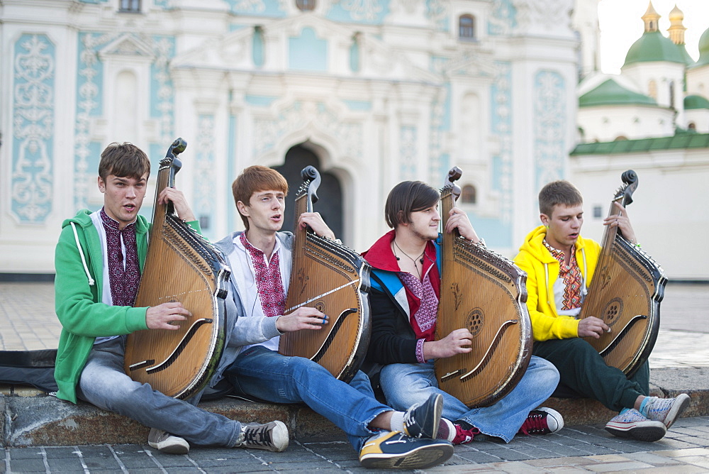 Four young Ukrainian bandurists playing banduras and singing in front of St. Sophia's Cathedral in Kiev, Ukraine, Europe