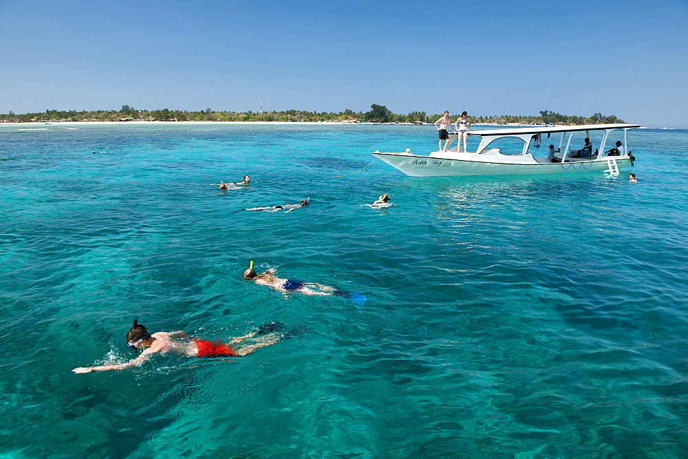 Tourist boat with snorkelers off the coast of Gili Air island in Indonesia.