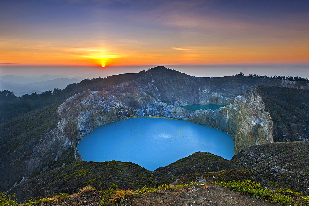 Sunrise over Tiwu Ko'o Fai Nuwa Muri, one of three crater lakes on the summit of Mount Kelimutu on Flores island, Indonesia.