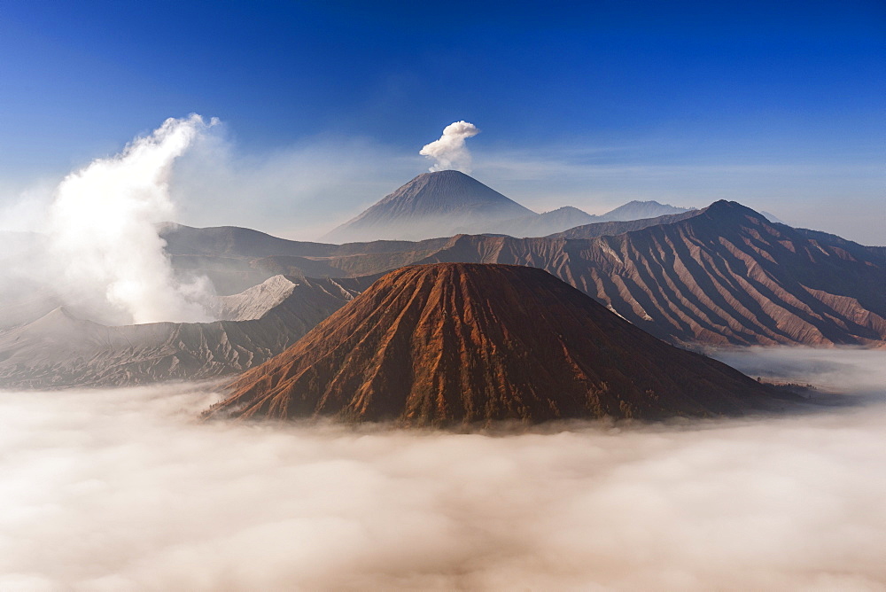 Mount Bromo (venting steam, left) and Gunung Semeru (centre background) in Bromo Tengger Semeru National Park, Java, Indonesia.