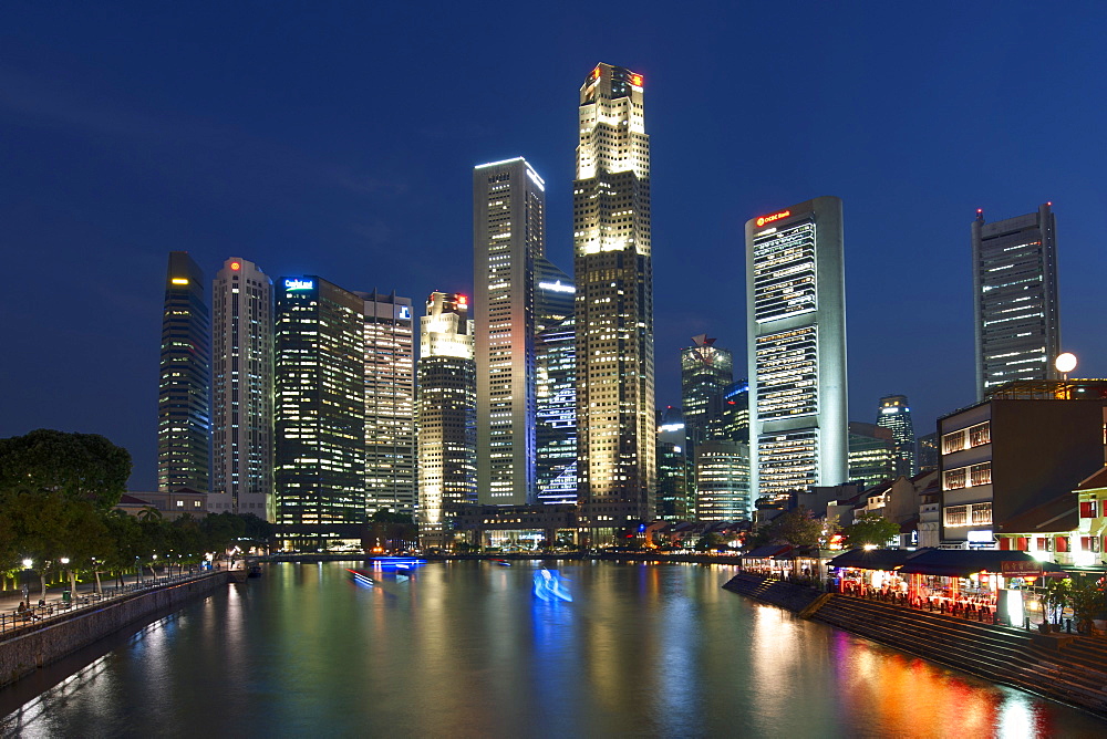 Boat Quay and the Singapore skyline and river at dusk.