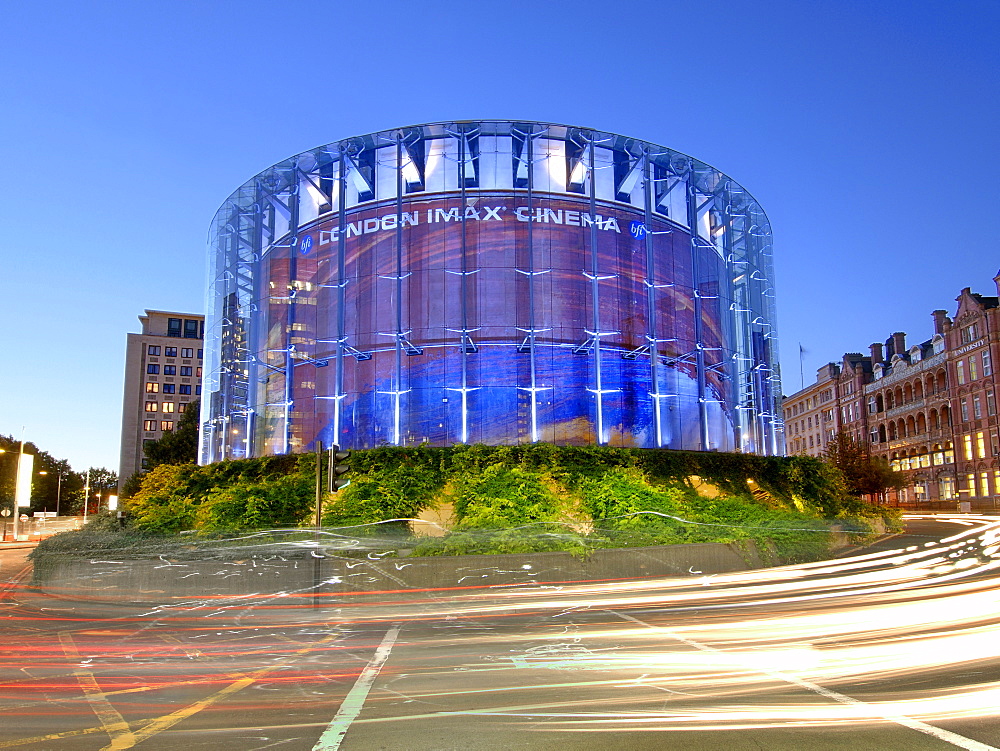 London's IMAX cinema and passing traffic at dusk.