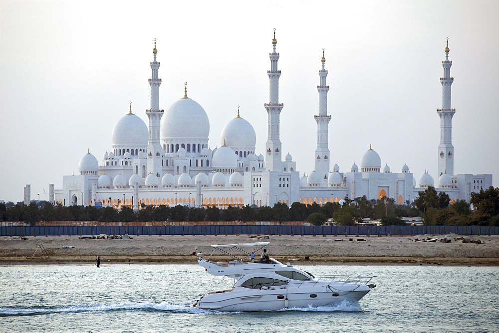 A luxury motor boat cruising past the Sheikh Zayed Grand Mosque in Abu Dhabi, capital of the United Arab Emirates.