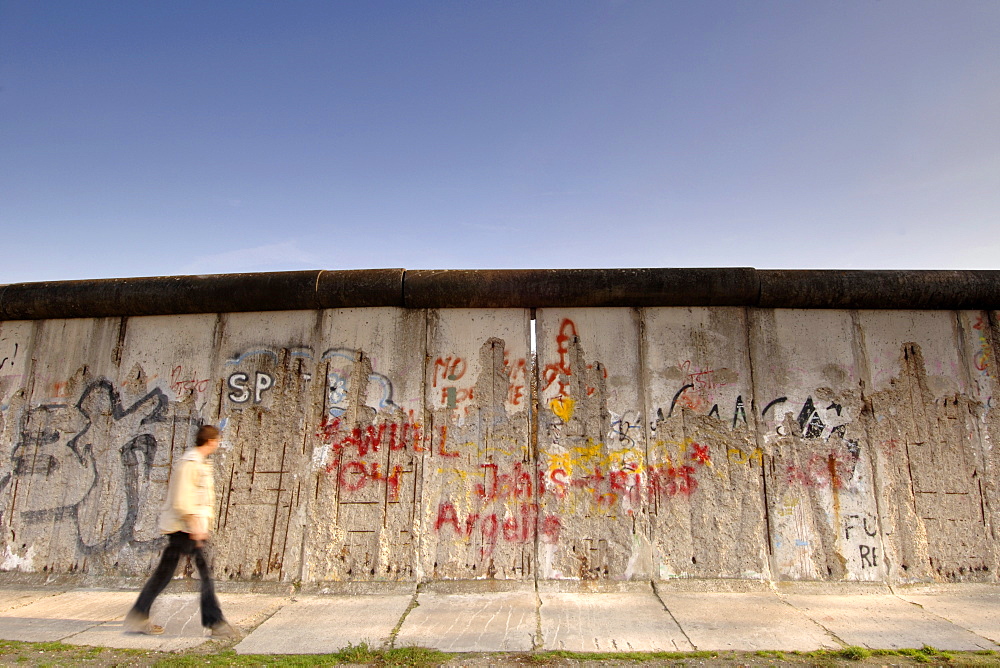 A man walking past the Berlin Wall along Bernauer Strasse, East Berlin, Germany, Europe