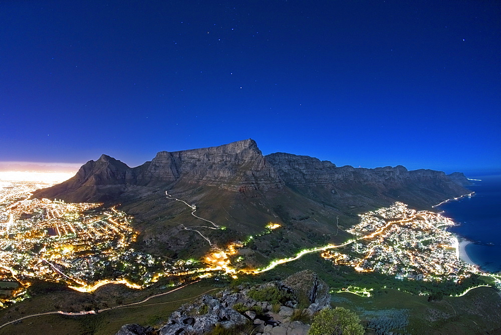 Table Mountain under full moon light with stars in the sky, Cape Town, South Africa.