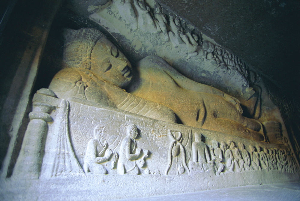 Rock cut reclining statue of the Buddha preparing to enter nirvana, in cave 26, a chaitya in the Buddhist cave site at Ajanta, carved from a gorge in the Waghore River, Ajanta, Maharashtra State, India.