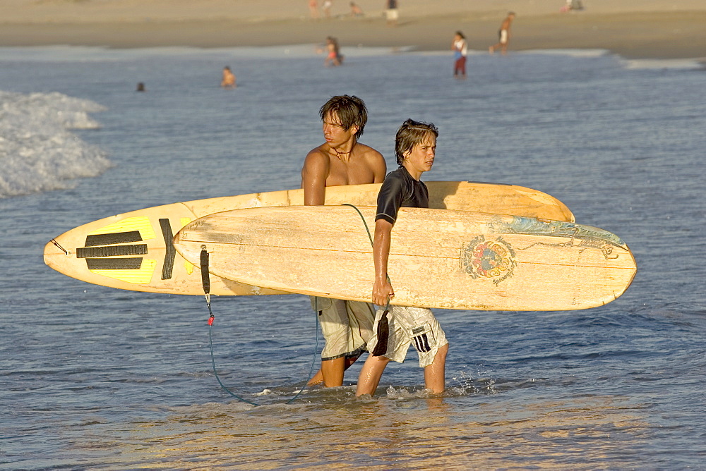 Young surfers on the beach at this popular surfing resort in the far north near the Ecuadorean border, Mancora, Peru, South America


