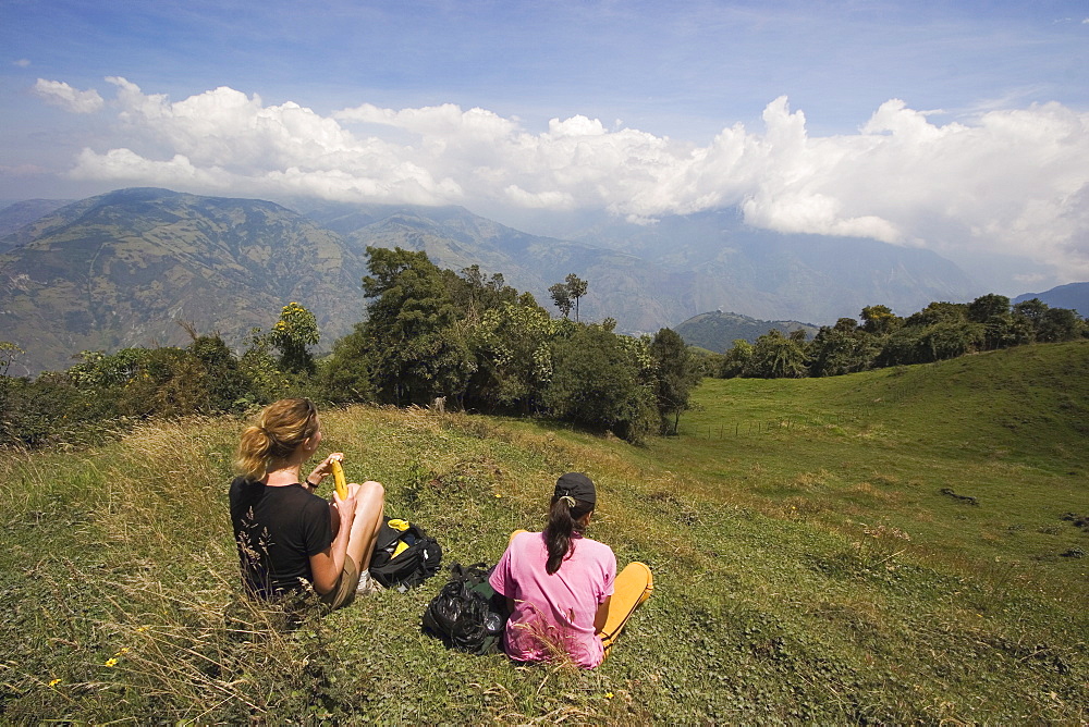 Hikers enjoy the view on the verdant slopes of the active Tungurahua Volcano that threatens the nearby town of Banos, Ambato Province, Central Highlands, Ecuador, South America