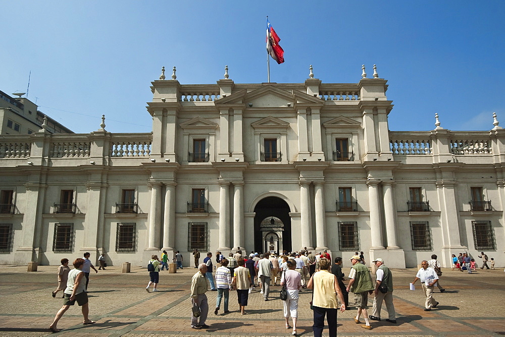 Visitors crossing the Plaza de La Constitucion and the Palacio de La Moneda, formerly a colonial mint, now the seat of the President, Civic District, Santiago, Chile, South America