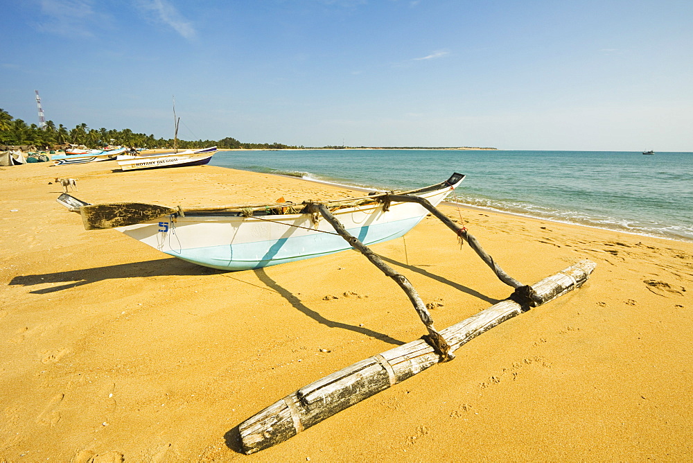 Old style outrigger fishing boat and post-2004 tsunami foreign donated newer ones beyond, Arugam Bay, Eastern Province, Sri Lanka, Asia