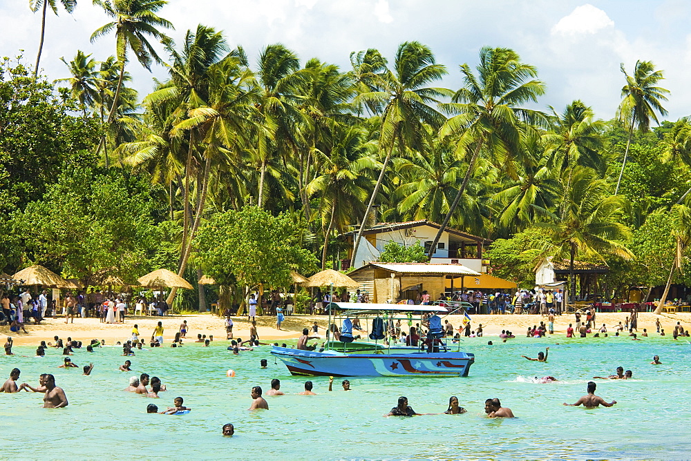 Sri Lankans swimming at the west end of this popular resort and beach, wrecked by the 2004 tsunami, Unawatuna, Galle, Sri Lanka, Asia