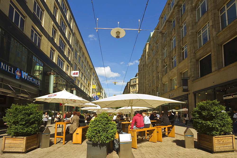 People sitting al fresco under parasols outside restaurant on pedestrianised shopping street, Spitalerstrasse, Hamburg, Germany, Europe