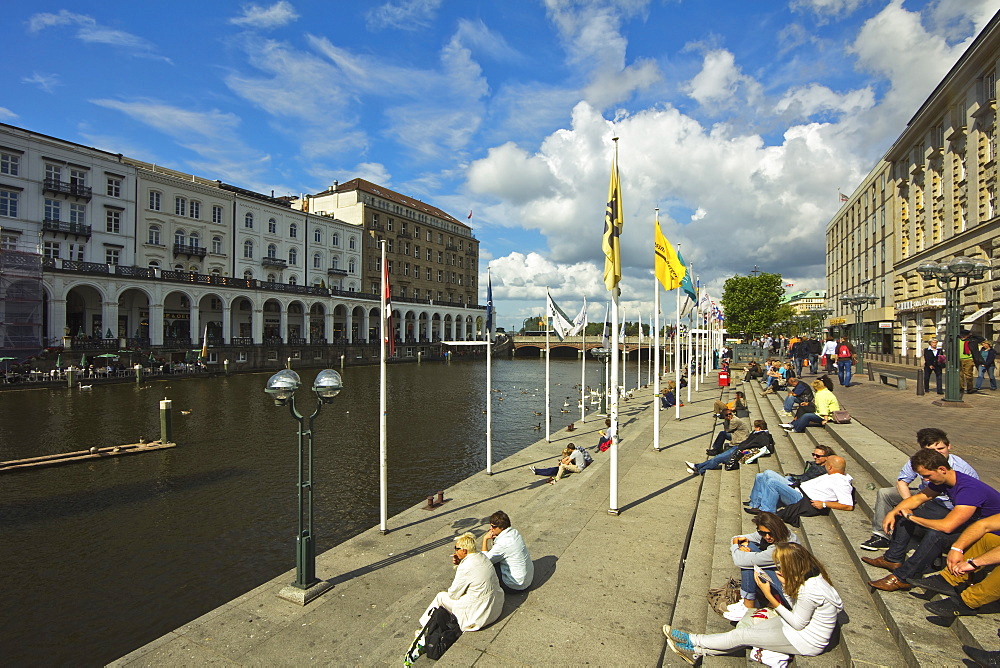 People sitting by the Alster River on the Reesendamm near the Rathausmarkt in this popular district of the city, Hamburg, Germany, Europe