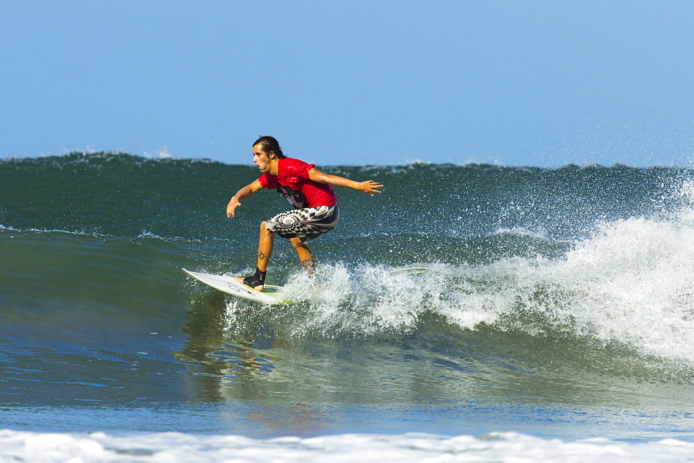 Surfer on shortboard riding wave at popular Playa Guiones surf beach, Nosara, Nicoya Peninsula, Guanacaste Province, Costa Rica, Central America