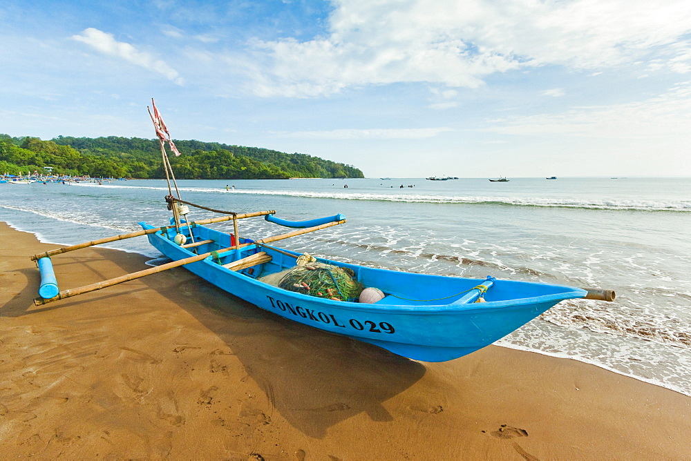 Outrigger fishing boat on west beach of the isthmus at this major beach resort on the south coast, Pangandaran, Java, Indonesia, Southeast Asia, Asia