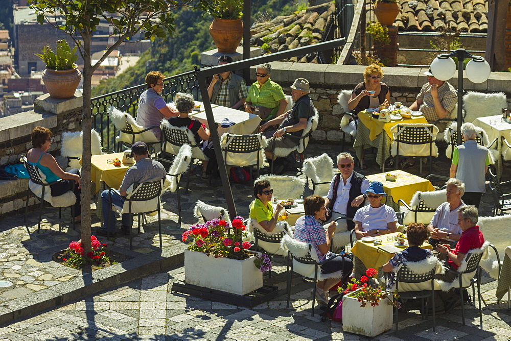 People alfresco on cafe terrace in spring at this pretty village high over Taormina, Castelmola, Catania Province, Sicily, Italy, Europe