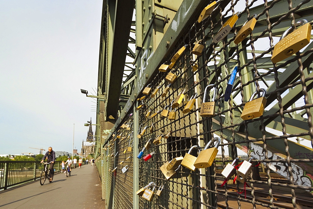 Cyclists padlocks on the Hohenzollern railway and pedestrian bridge over the River Rhine, Cologne, North Rhine-Westphalia, Germany, Europe