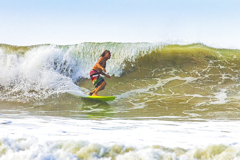 Middle-aged man surfing at this hip resort near Mal Pais, far south  of Nicoya Peninsula, Santa Teresa, Puntarenas, Costa Rica, Central America