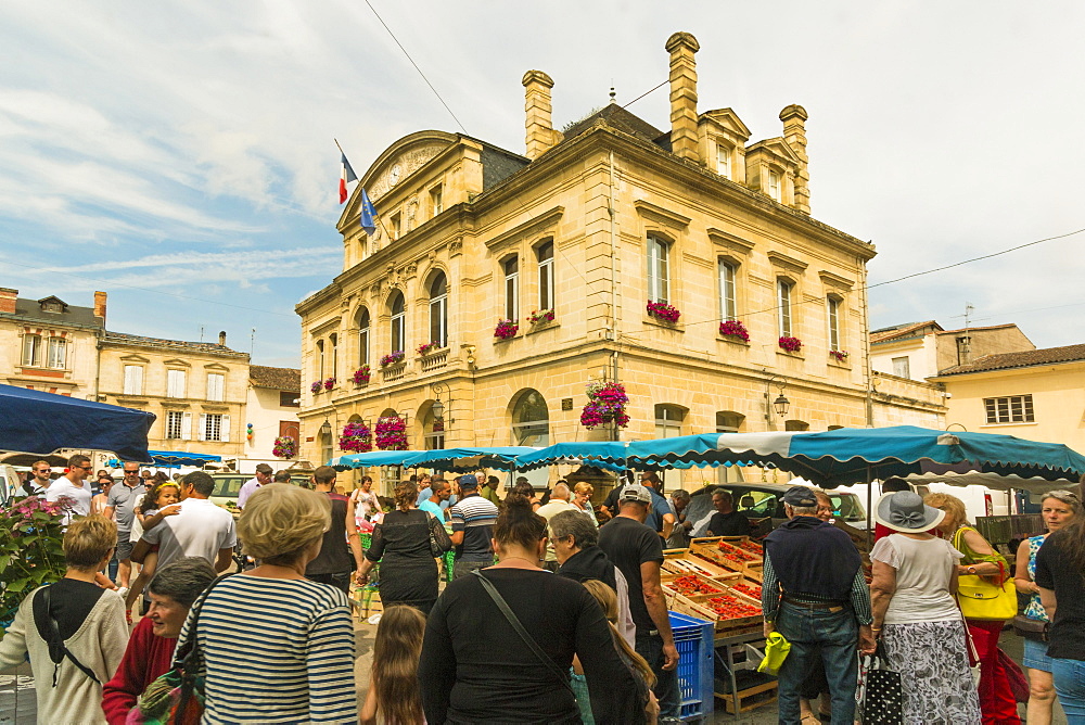 Stalls and the Mairie in town hall square on market day in this old bastide town, Sainte-Foy-la-Grande, Gironde, Aquitaine, France, Europe