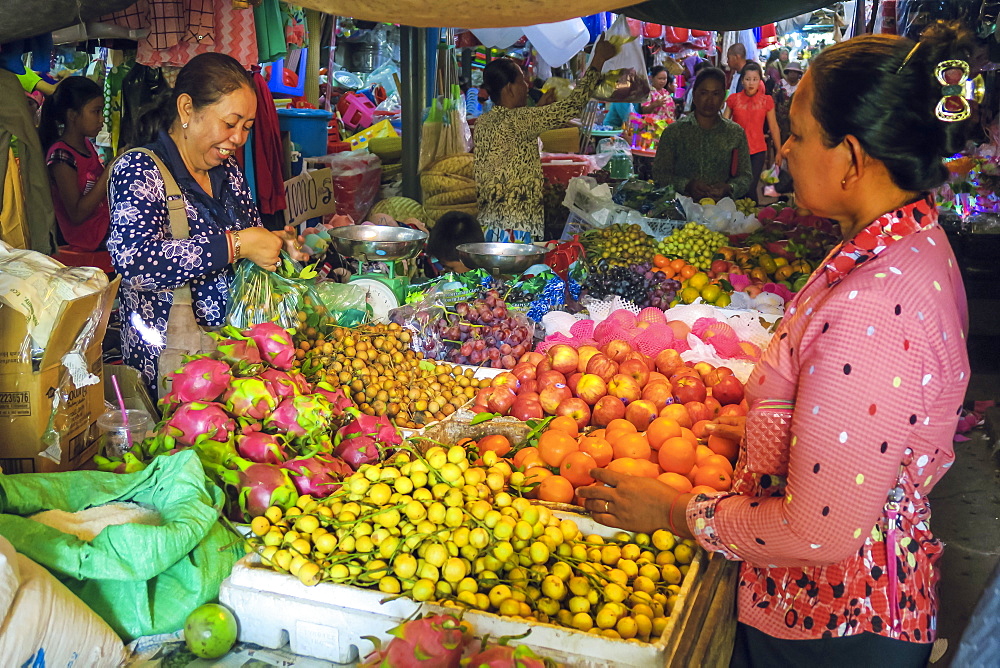 Woman shopping at a fruit stall in the central market at this old formerly French colonial river port city, Kampot, Cambodia, Indochina, Southeast Asia, Asia