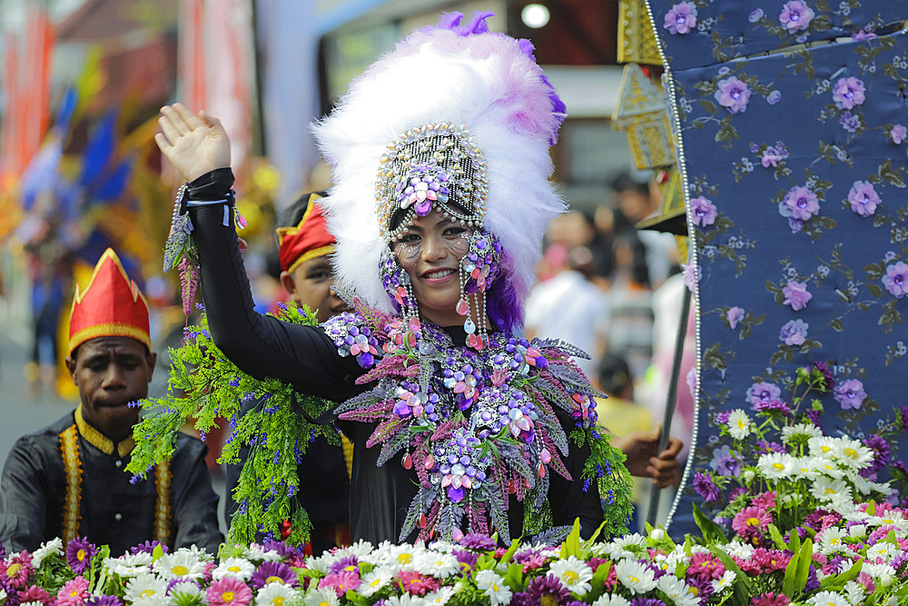 Waving woman in costume at the annual Tomohon International Flower Festival parade, Tomohon, North Sulawesi, Sulawesi, Indonesia, Southeast Asia, Asia