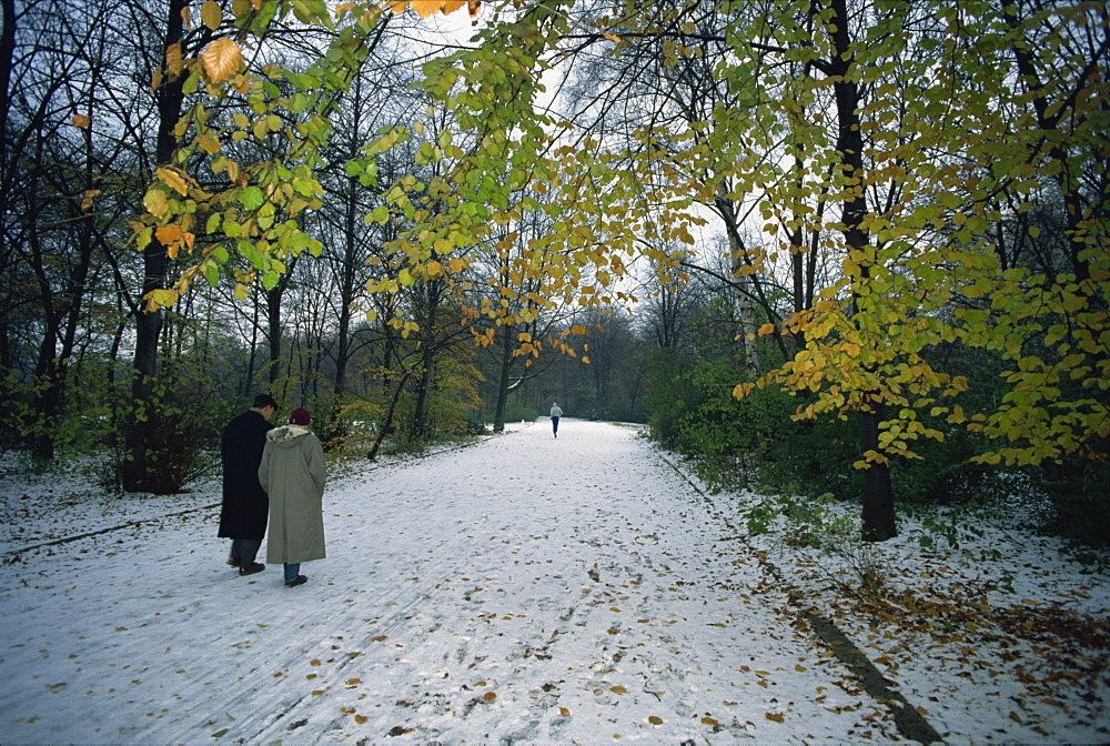 Couple walking in the snow in the Tiergarten, Berlin, Germany, Europe