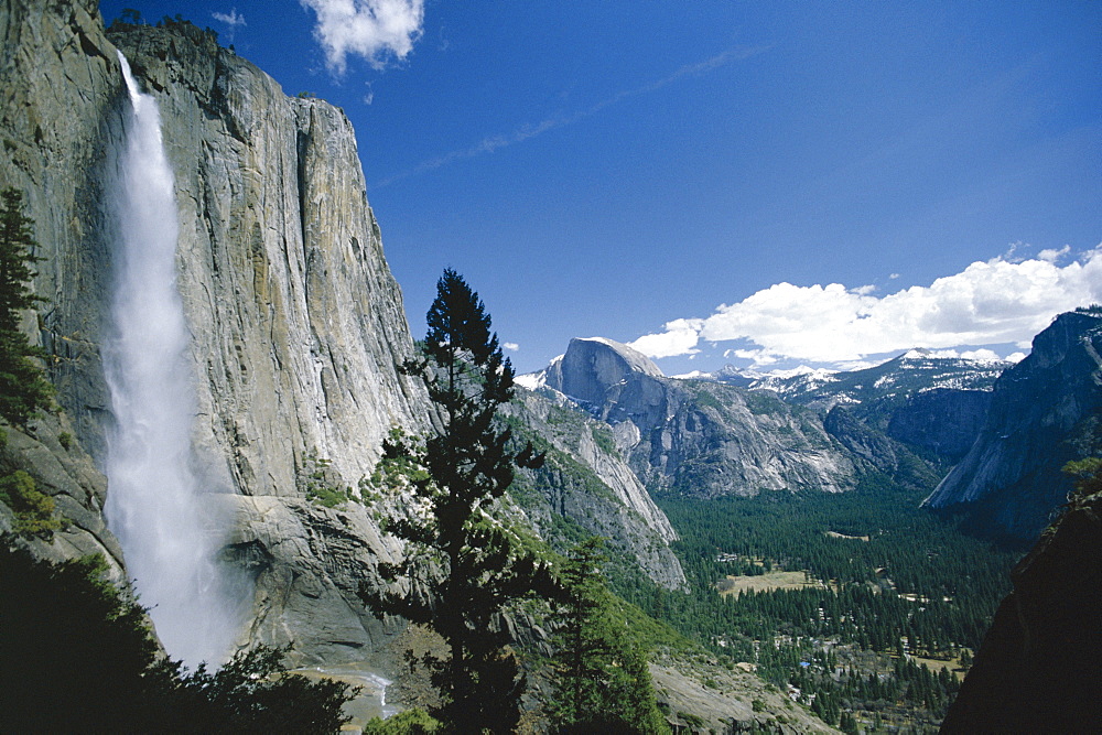 Upper Yosemite Falls cascades down the sheer granite walls of Yosemite Valley, the world's longest unbroken fall, with the famous 8842 ft Half Dome in the distance, Yosemite National Park, UNESCO World Heritage Site, California, United States of America (U.S.A.), North America