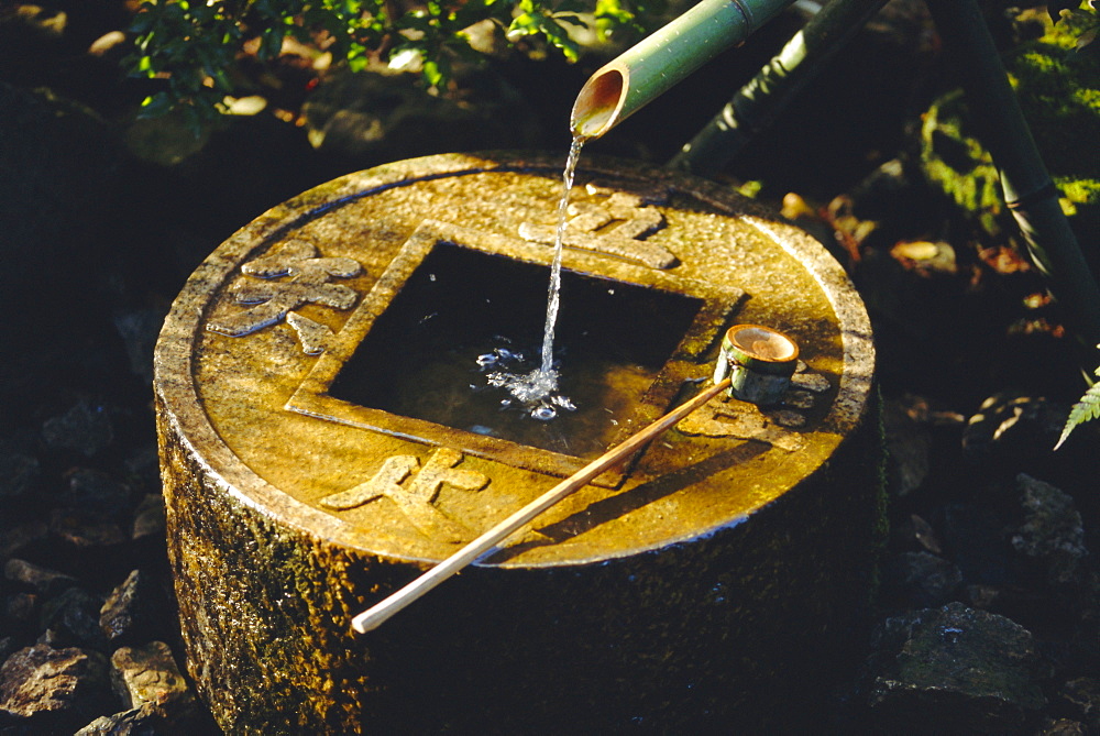 A Tsubakai, a stone wash basin for the tea room, Ryoan-ji Temple in NW Kyoto, Honshu, JapanThe Zen inscription reads 'I learn only to be contented'