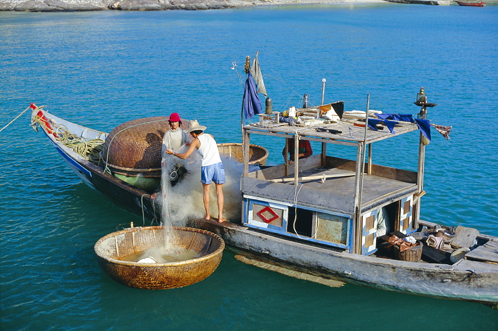 Fisherman sorting nets out of a traditional thung chai (basket boat) at Mieu Island, Nha Trang, Vietnam, Indochina, Southeast Asia, Asia