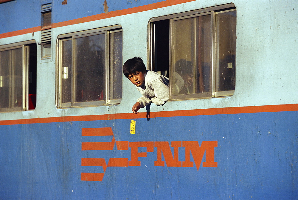 Portrait of a boy leaning out of a train window at Chihuahua, Mexico, North America