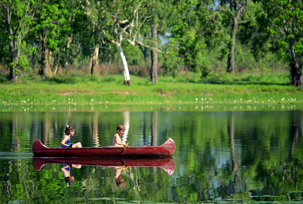 Children canoeing in Annaburroo Billabong at Mary River Crossing near the Arnhem Highway, at the Top End, Northern Territory, Australia, Pacific