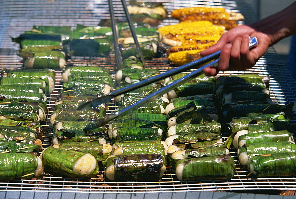 Sticky rice wrapped in banana leaves on barbecue at Vietnamese Lunar New Year Festival in Footscray, a suburb of Melbourne, Victoria, Australia, Pacific