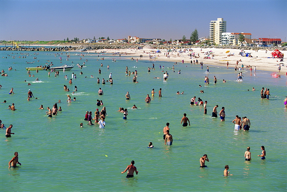 Groups of people in the sea and on the beach at Glenelg, a resort suburb of Adelaide, where first South Australian colonists landed, South Australia, Australia, Pacific