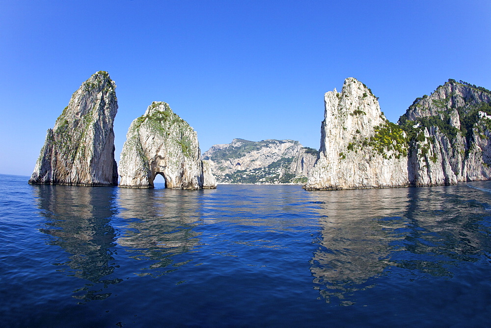 Faraglioni Rocks taken from the sea in early morning summer sunshine, Isle of Capri, Campania, Italy, Europe