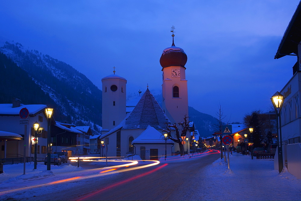 Church in winter snow at dusk, St. Anton am Arlberg, Austrian Alps, Austria, Europe