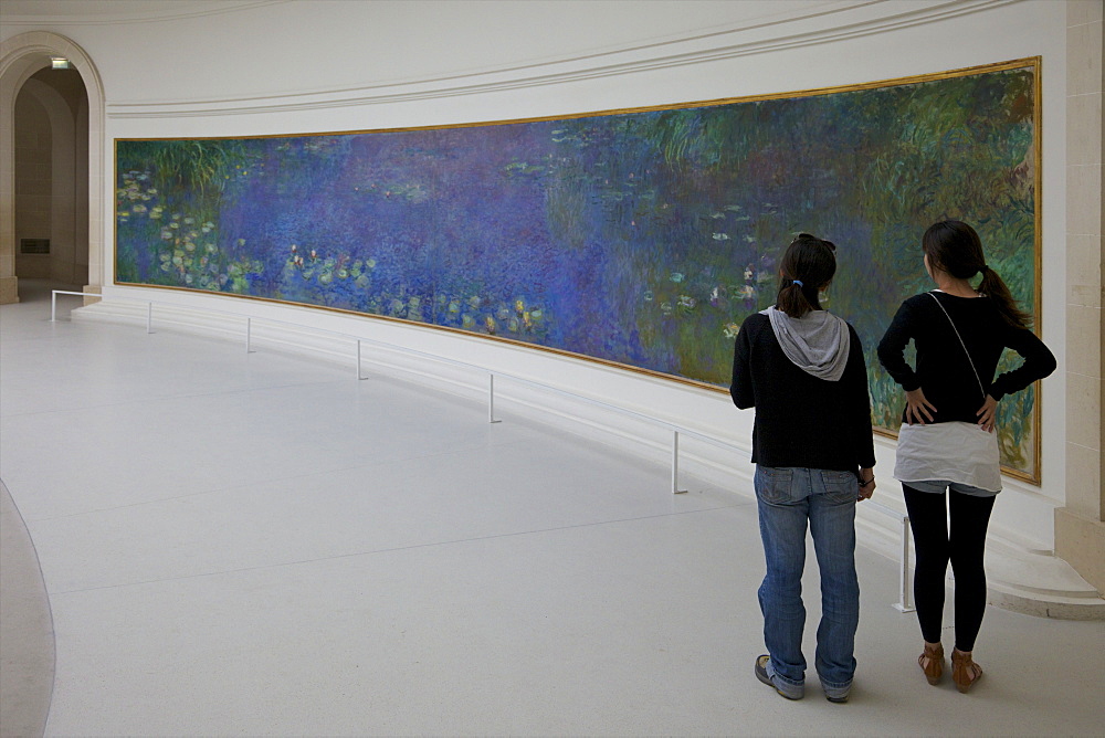 Two young women admire the Water-lilies by Claude Monet, Musee de L'Orangerie Museum, Paris, France, Europe