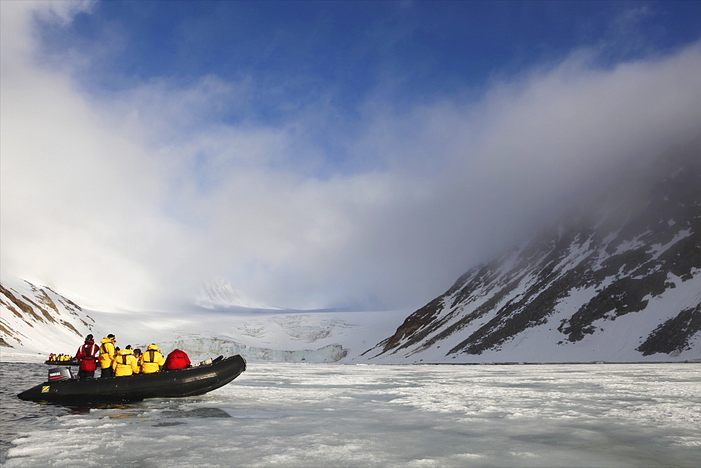 Zodiac inflatable with tourists exploring Arctic landscape in summer sunshine, northern Spitzbergen, Svalbard, Norway, Scandinavia, Europe