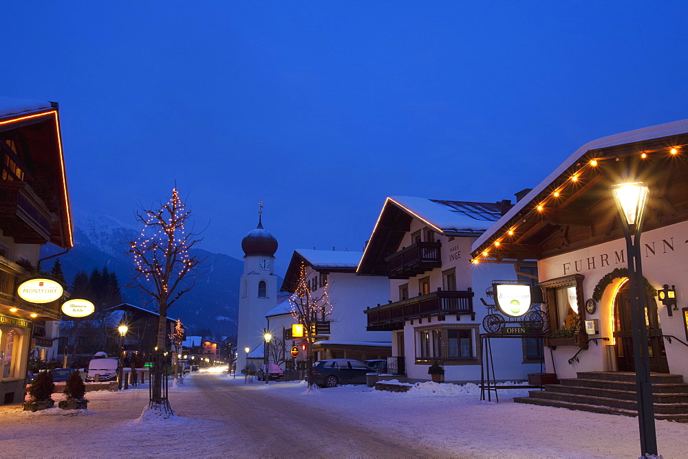 St. Anton am Arlberg main road and church in winter snow in the evening, Tyrol, Austrian Alps, Austria, Europe