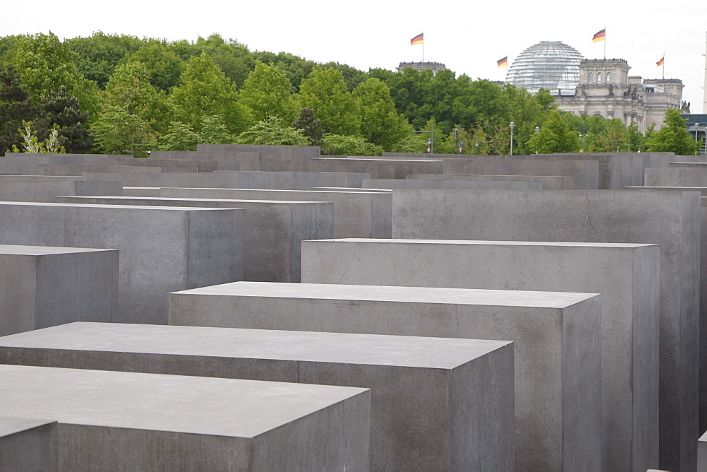 Field of steles, designed by Peter Eisenman, the Memorial to the Murdered Jews of Europe, the Reichstag building at back, Bundestag, Berlin, Germany, Europe