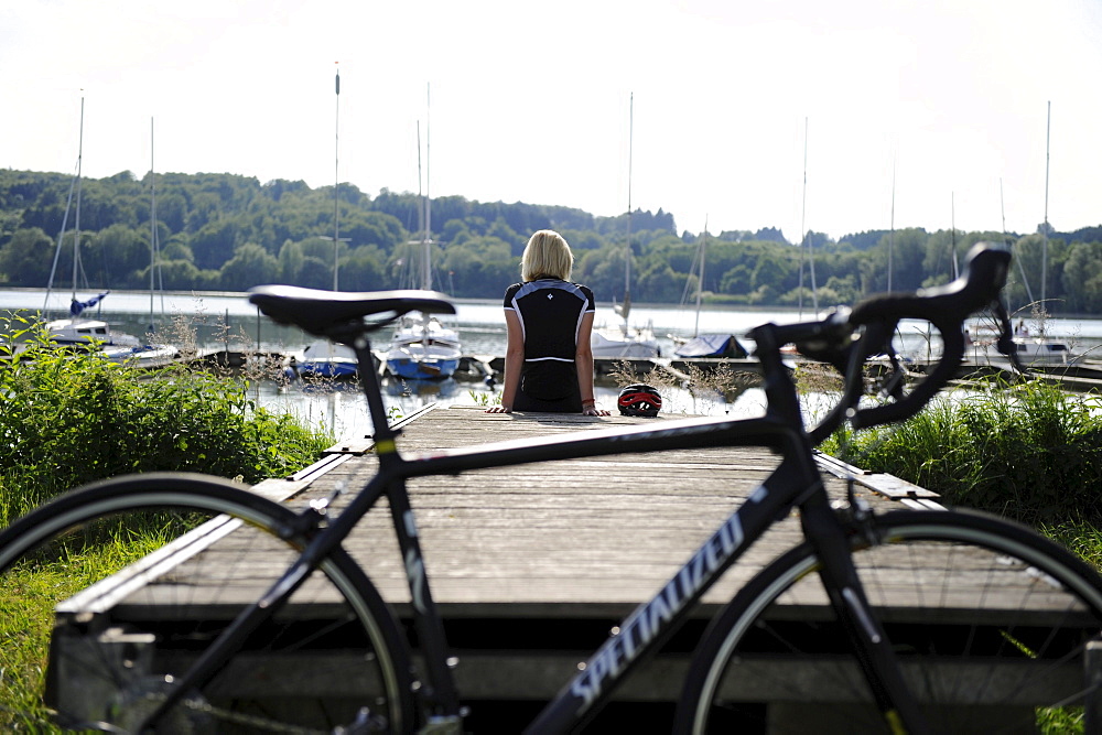 Woman resting on a jetty on Wiesensee lake in Pottum, Westerwald, Rhineland-Palatinate, Germany, Europe