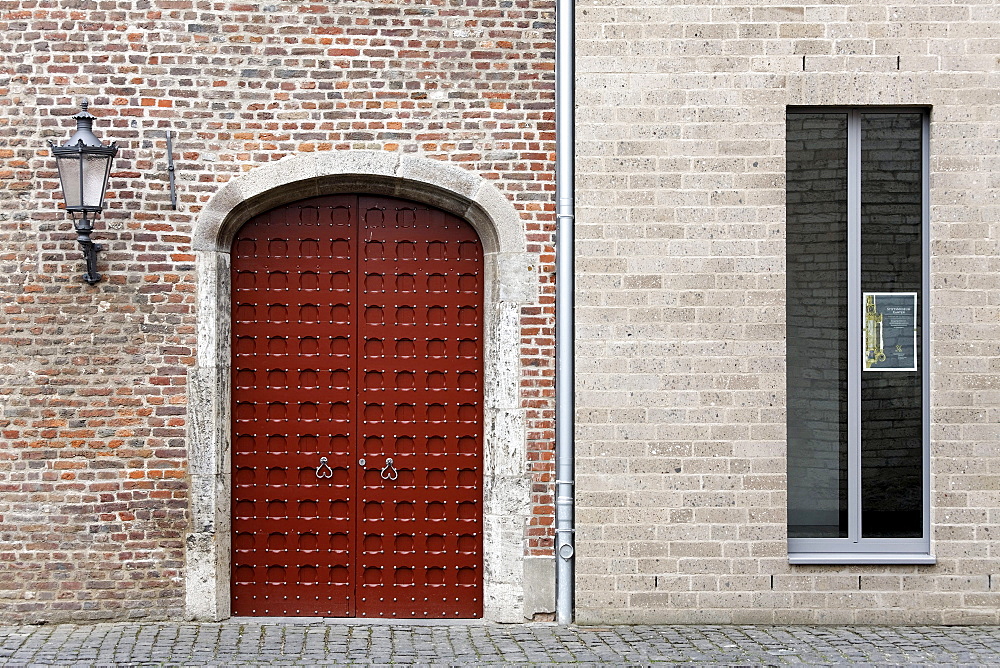 Medieval brick wall with gate side by side with a new wall with modern windows, Stiftsmuseum monastery museum, Xanten, Lower Rhine region, North Rhine-Westphalia, Germany, Europe