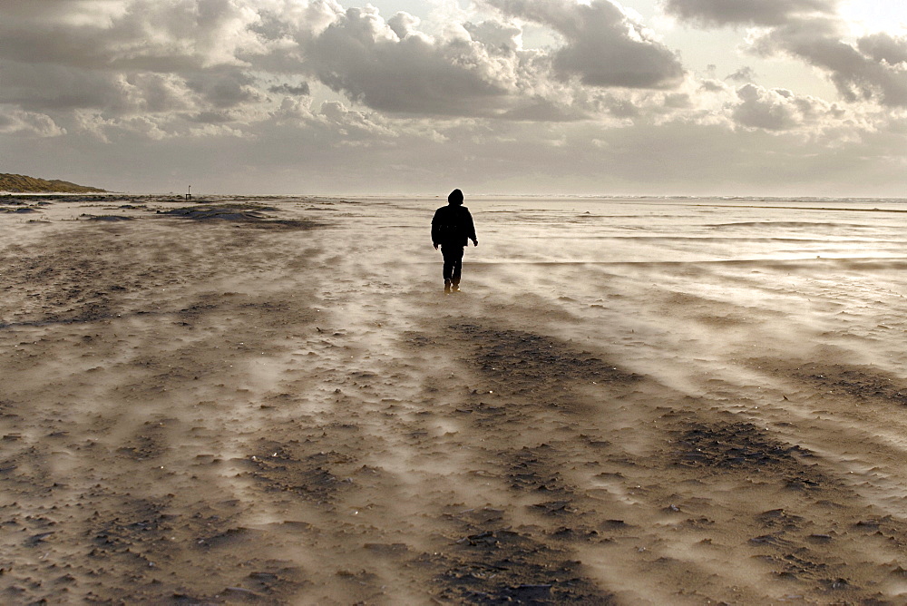 Lone figure of a person on a windy beach, island of Juist, Lower Saxony, North Germany, Europe